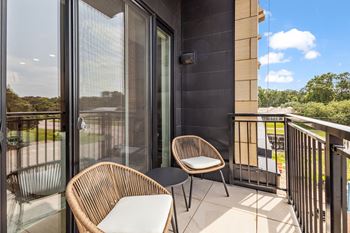 A balcony with a chair and a table.